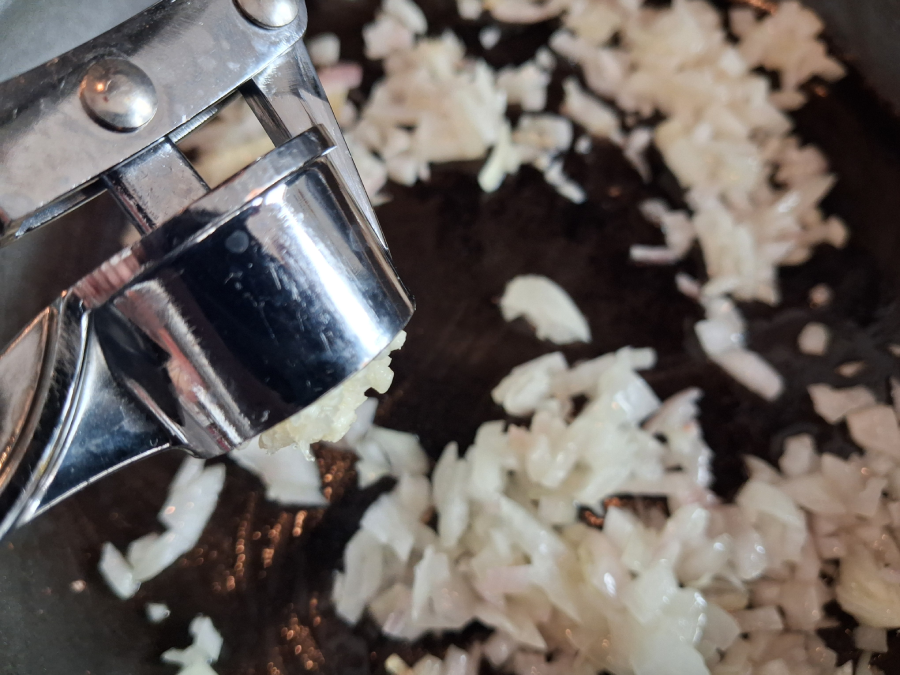 Prelisovanie cesnaku do cibule počas restovania