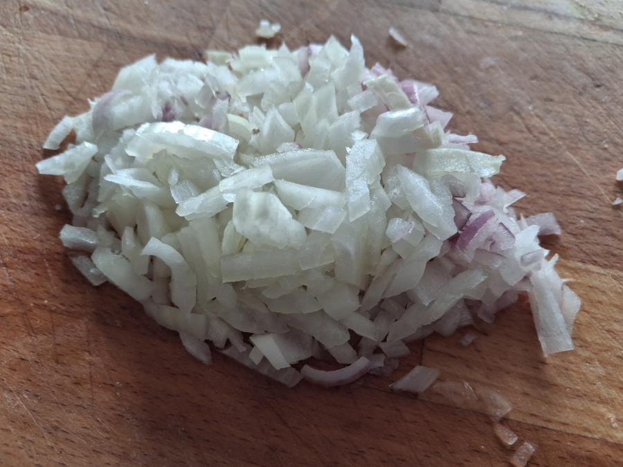 Nadrobno nakr&aacute;jan&aacute; cibuľa na doske